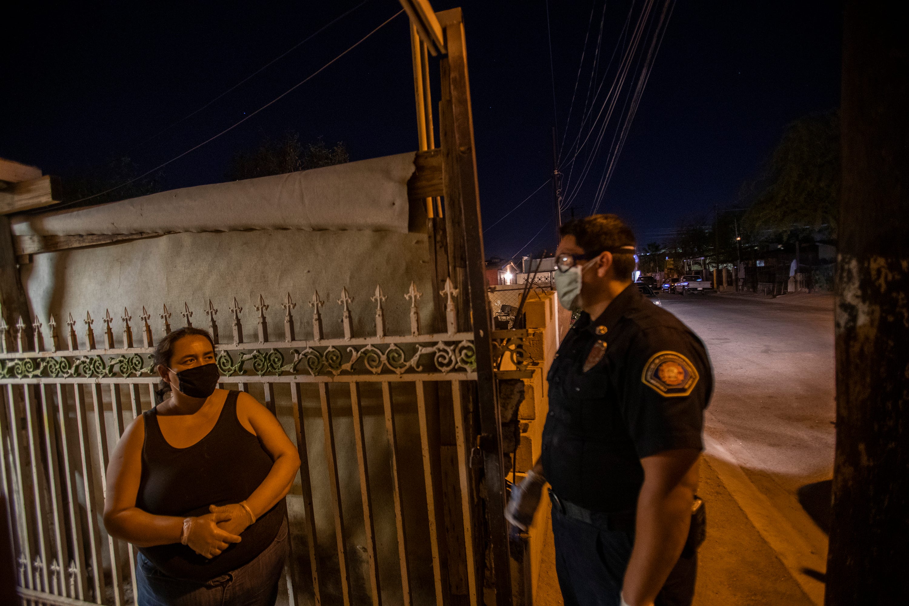 Angel Valladolid Pimentel gives instructions to a woman who has a brother and her father diagnosed with COVID-19 at her home on Wednesday May 27, 2020.