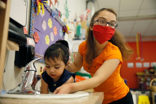 Paloma Martinez helps Milan Llanas wash her hands during play hour at daycare Tuesday, May 27, at the 1600 N. Brown location in El Paso.