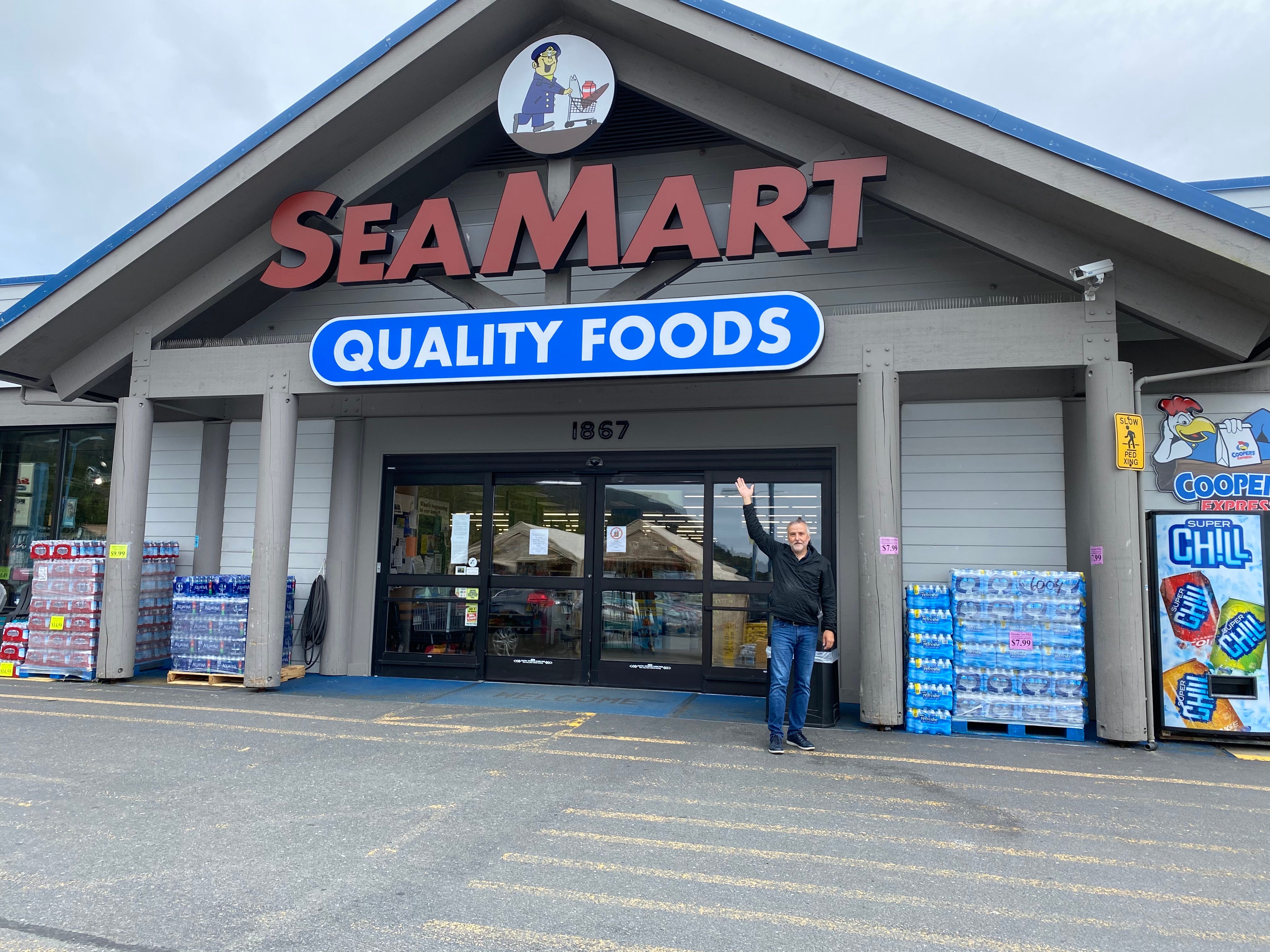 Grocer Max Rule poses in front of his store, Sea Mart.