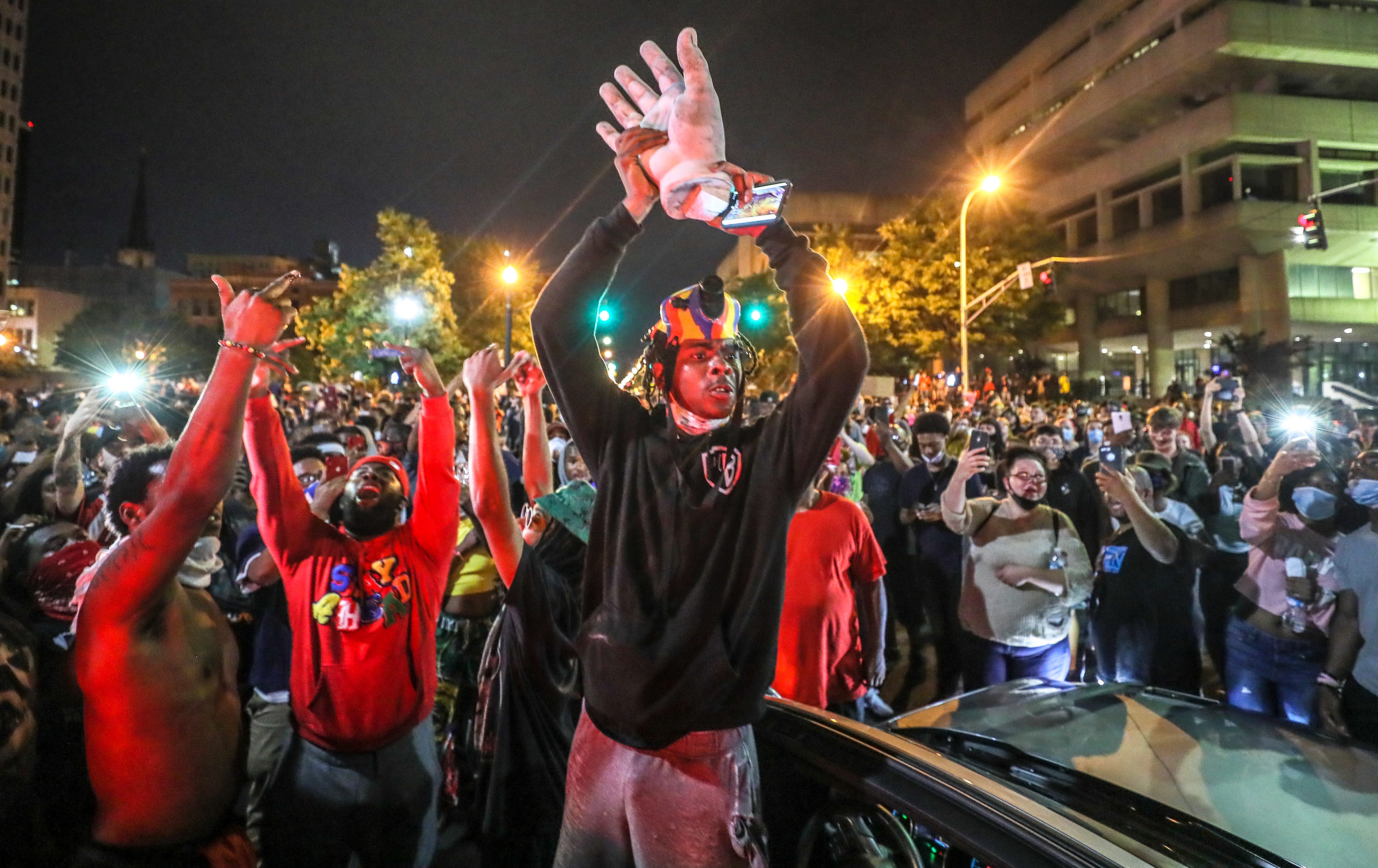 A protester holds up the hand of King Louis XVI after it was torn from the statue during a protest on Thursday, May 28, 2020