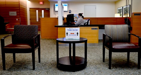 Chairs spaced apart and a sign asking for social distancing in a waiting room at Dana Farber Cancer Institute in Boston, Wednesday, May 20, 2020