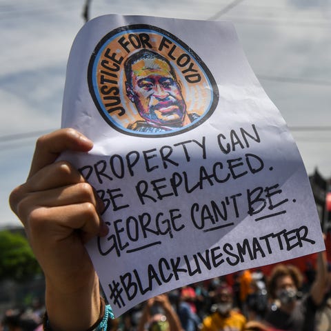 People hold signs near the Minneapolis Police Depa