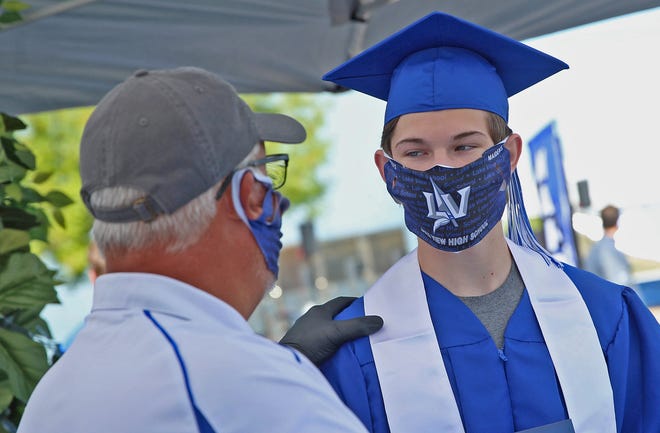 A member of the Lake View High School class of 2020 accepts his diploma during a drive thru ceremony Saturday, May 30, 2020.