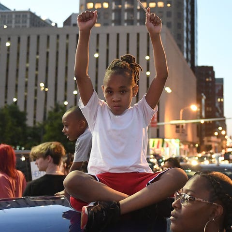 A child holds an American Flag as protestors march