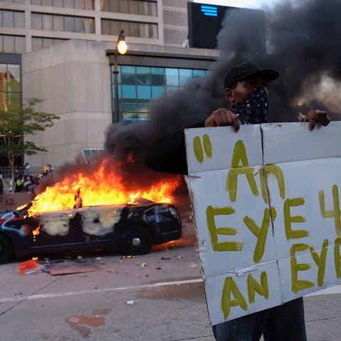 A police car burns during a protest in Atlanta, Fr