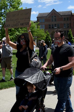Jamie Holderman, of Newark, holds he sign aloft while walking with her husband Drew and son Dawson during a protest at the Licking County Courthouse on May 31, 2020. Protesters gathered in downtown Newark to stand in solidarity and fight against hate during the Together We Rise rally.