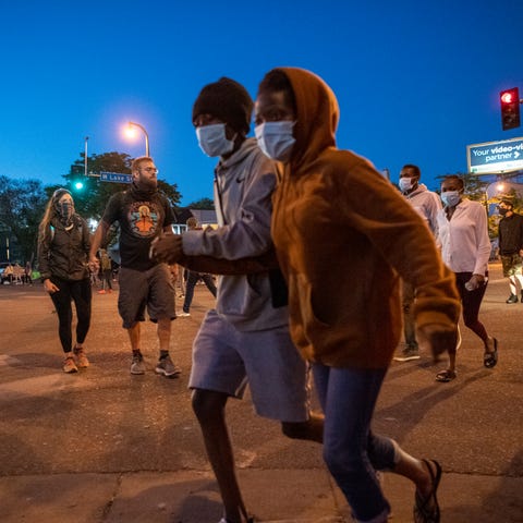 Demonstrators run during protests in Minneapolis o