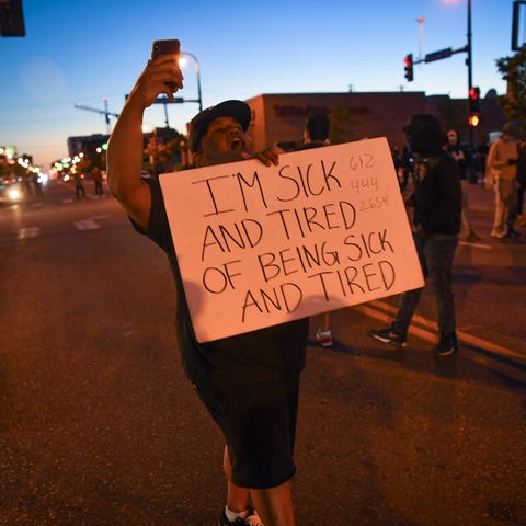 A demonstrator carries a sign as they protest in d