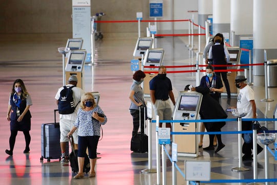 Travelers check in at the American Airlines terminal at the Los Angeles International Airport Thursday, May 28, 2020, in Los Angeles.