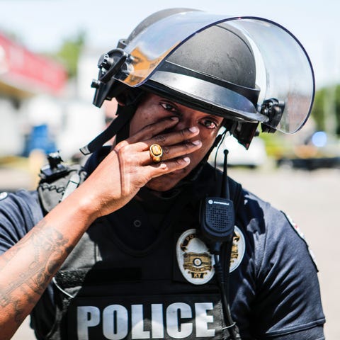 LMPD officer Christian Lewis wipes tears away afte