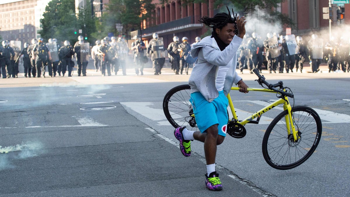 A protestor grabs his bike as the police uses tear gas and rubber bullets to disperse the crowd gathered near the White House on June 1, 2020 as demonstrations against George Floyd's death continue.