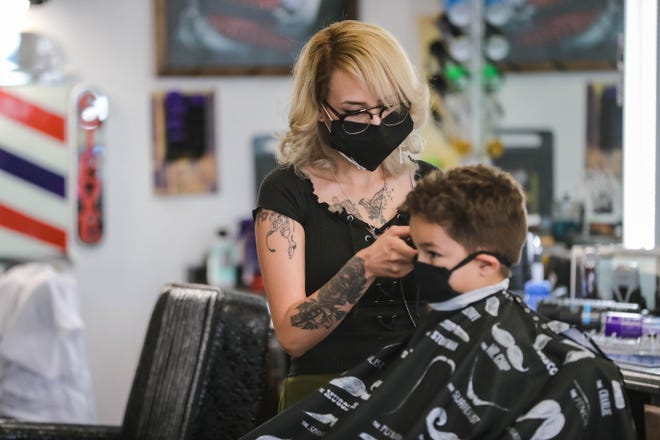 Aeyla Trujillo cuts hair while wearing a mask at Classic Cuts Barbershop in Las Cruces on Tuesday, June 2, 2020.