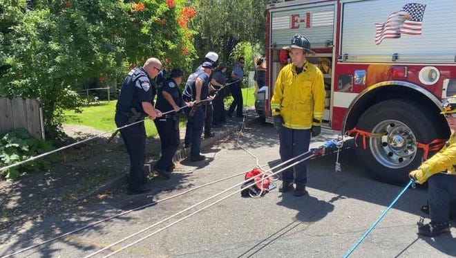 Redding police and firefighters use ropes to bring an officer and a 4-year-old girl to safety after the child tumbled down a 70-foot cliff Wednesday, June 3, 2020, next to the Sacramento River.