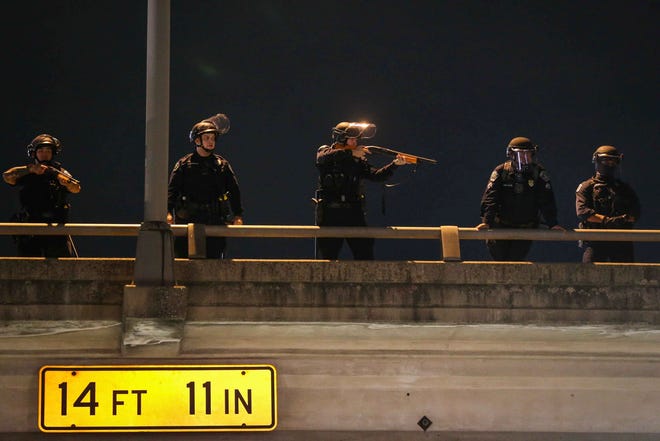 An Austin police officer aims a weapon with rubber bullets into the crowd of protestors calling for justice over the death of George Floyd in Austin on Sunday, May 31, 2020.