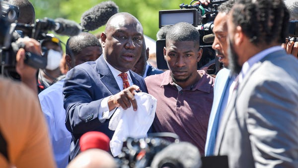 Civil rights attorney Benjamin Crump, left, puts h