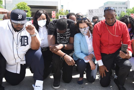 Gov.Gretchen Whitmer, center, prays with clergy including Bishop Charles Ellis of Greater Grace Church, right, on the corner of Woodward and Warren during a rally in honor of George Floyd, Thursday, June 4, 2020.