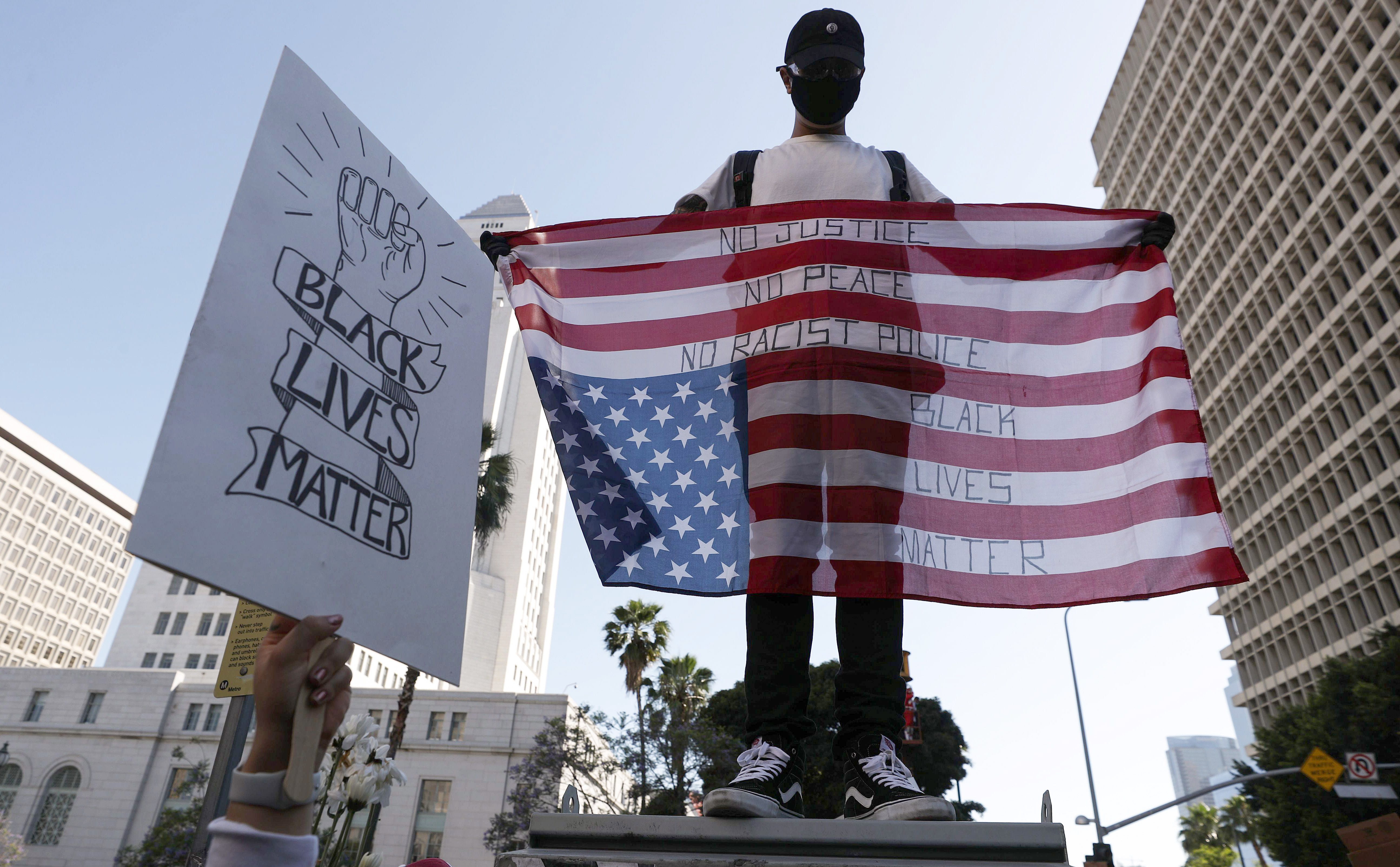 A protester displays an upside-down U.S. flag outside the District Attorney's office during a peaceful demonstration over George Floyd's death on June 3, 2020, in Los Angeles, California.