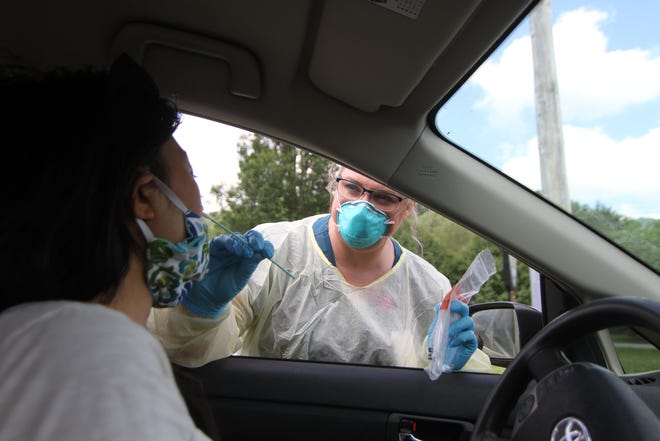 Wendy Owenby, the lead clinic nurse at the Madison County Health Department, performs a "patient friendly" COVID-19 test on a Madison County resident seated inside her car at a drive thru testing event June 3 in Madison County.