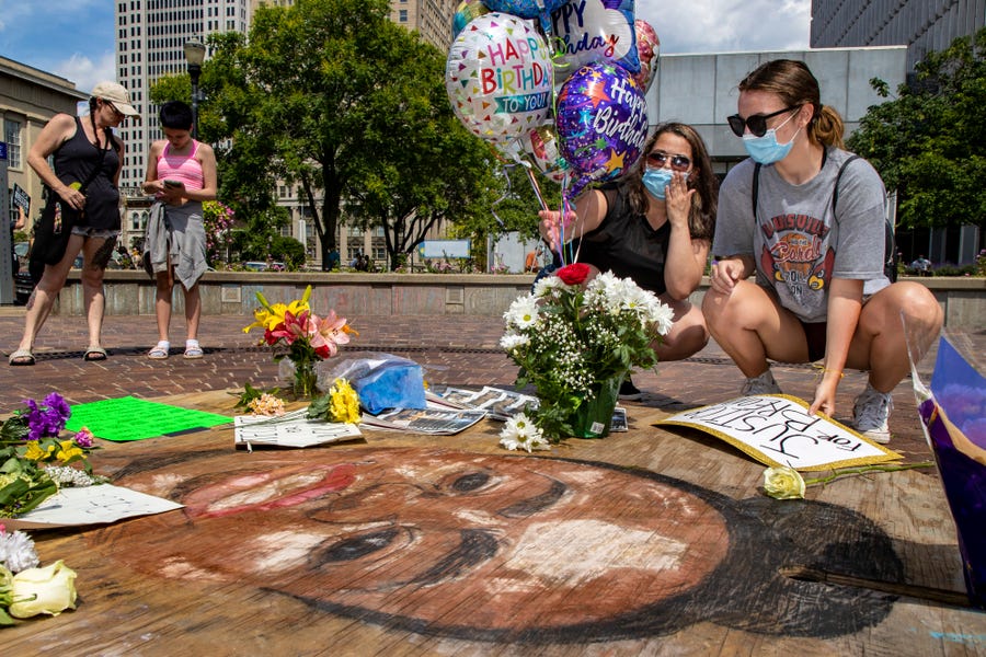 Alyssa Malone, from right, and Hannah Martinez place flowers and birthday balloons on a mural of Breonna Taylor in Jefferson Square Park. Friday would have been Breonna Taylor's 27th birthday. June 5, 2020