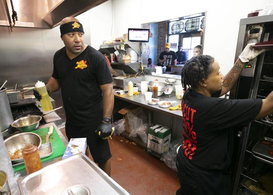 Phil Johnson, left, the owner of Trapp Haus BBQ, helps prep food alongside cook Zion Grinage at the barbecue restaurant in Phoenix on June 4, 2020.