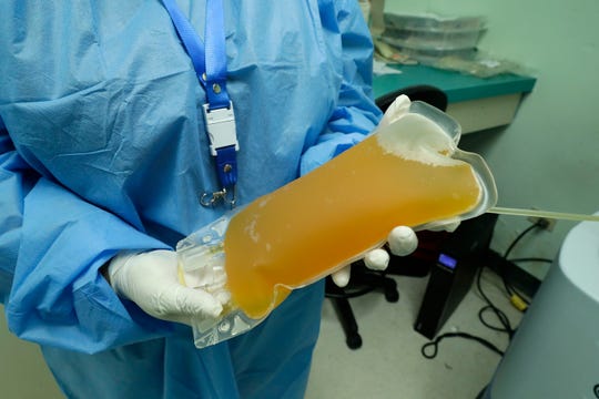 A doctor holds a donation of convalescent plasma from a recovered COVID-19 patient at the Arnulfo Arias Madrid Hospital, in Panama City, Wednesday, May 13, 2020.
