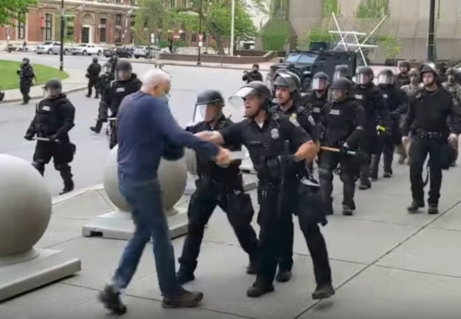In this image from video provided by WBFO, a Buffalo police officer appears to shove a man who walked up to police Thursday, June 4, 2020, in Buffalo, N.Y. Video from WBFO shows the man appearing to hit his head on the pavement, with blood leaking out as officers walk past to clear Niagara Square. Buffalo police initially said in a statement that a person â€œwas injured when he tripped & fell,â€ WIVB-TV reported, but Capt. Jeff Rinaldo later told the TV station that an internal affairs investigation was opened. Police Commissioner Byron Lockwood suspended two officers late Thursday, the mayorâ€™s statement said. (Mike Desmond/WBFO via AP)