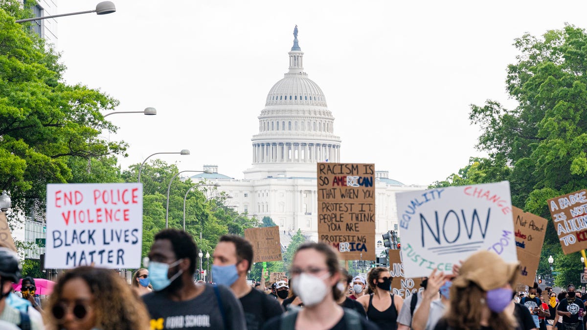 The United States Capitol building is seen as demonstrators display and march along Constitution Avenue in Washington, DC.