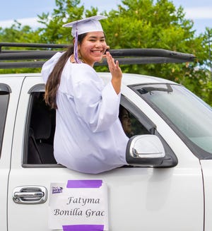 Fatima Grac waves from her car window during the parade honoring Yerington High School’s graduates.