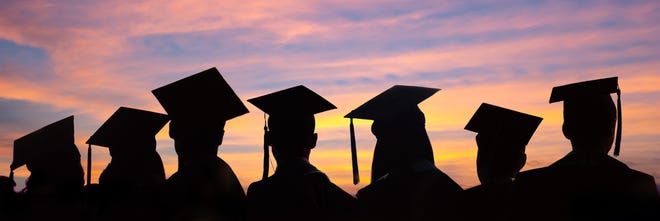 Silhouettes of students with graduate caps in a row.