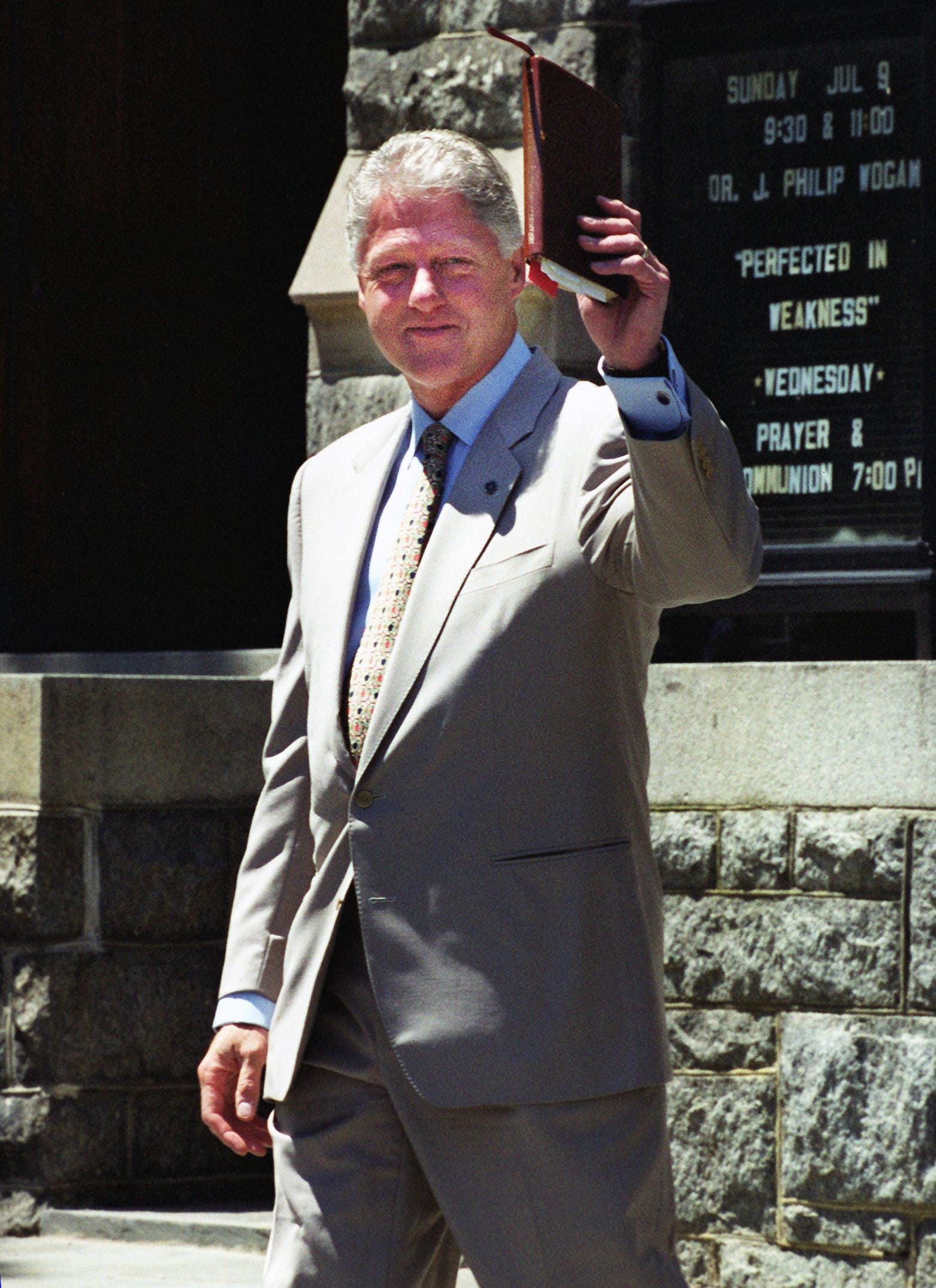 President Bill Clinton waves his Bible following a church service at Foundry United Methodist Church on July 9, 2000, in Washington, D.C.
