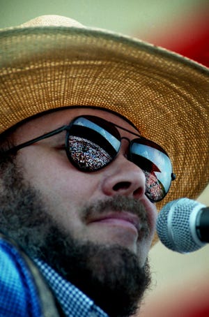 With the huge crowd reflected in his sunglasses, Hank Williams Jr. performs his rambunctious "Hog Wild" during the Curb Records show on the first full day of the 24th annual Fan Fair at the state fairgrounds June 6, 1995.