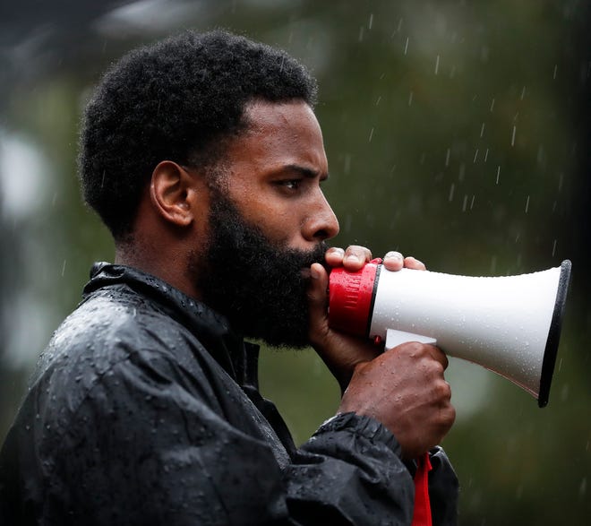 Tevin Taylor, who co-organized a protest in response to the killing of George Floyd in Minneapolis, speaks to about 100 people who marched throughout De Pere in the rain on June 10, 2020.