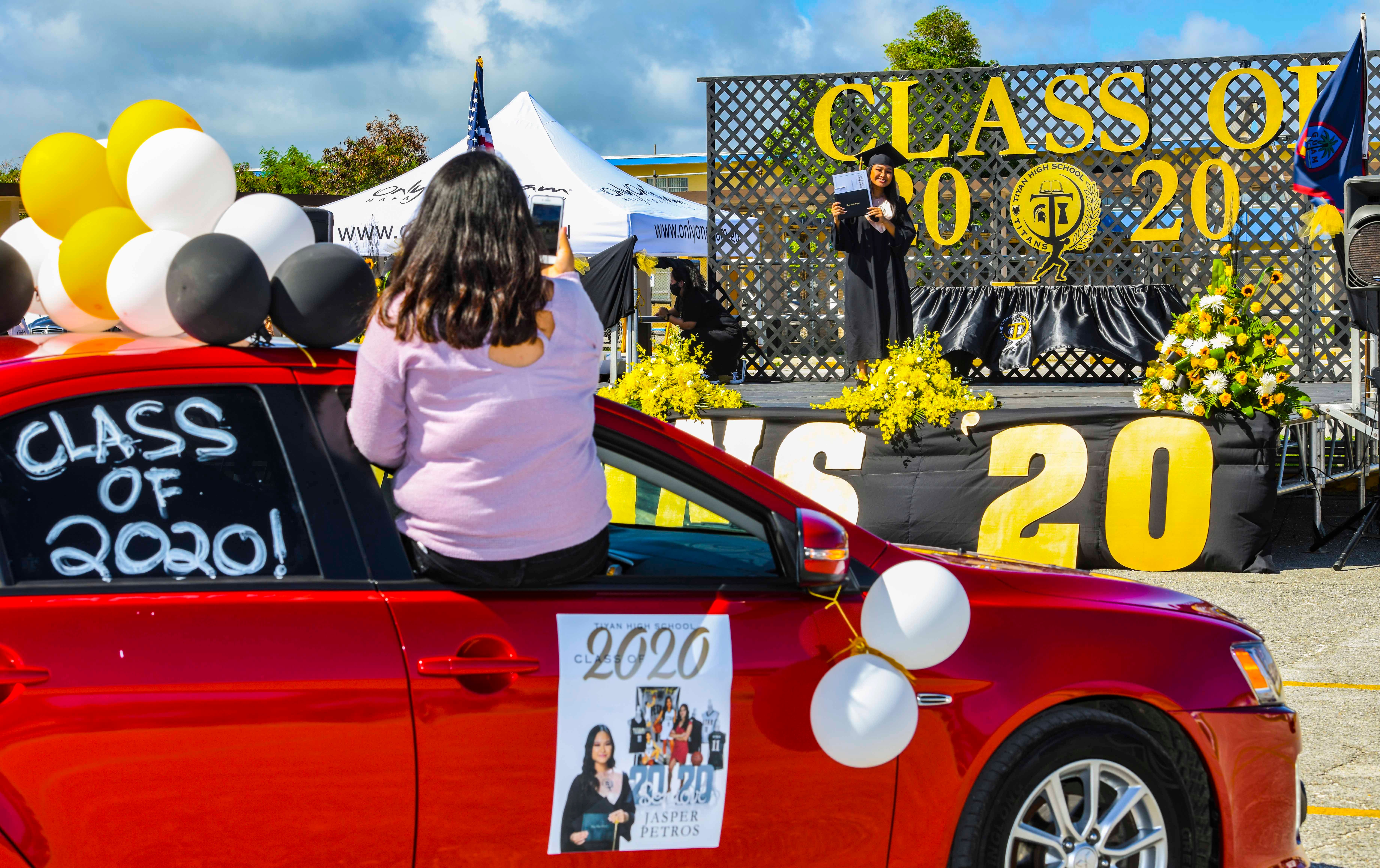 Titan graduate Jasper Petros is cheered on by family members after receiving her diploma during a Grad & Go ceremony for Tiyan High School's Class of 2020 at the Barrigada campus in this June 11, 2020, file photo.