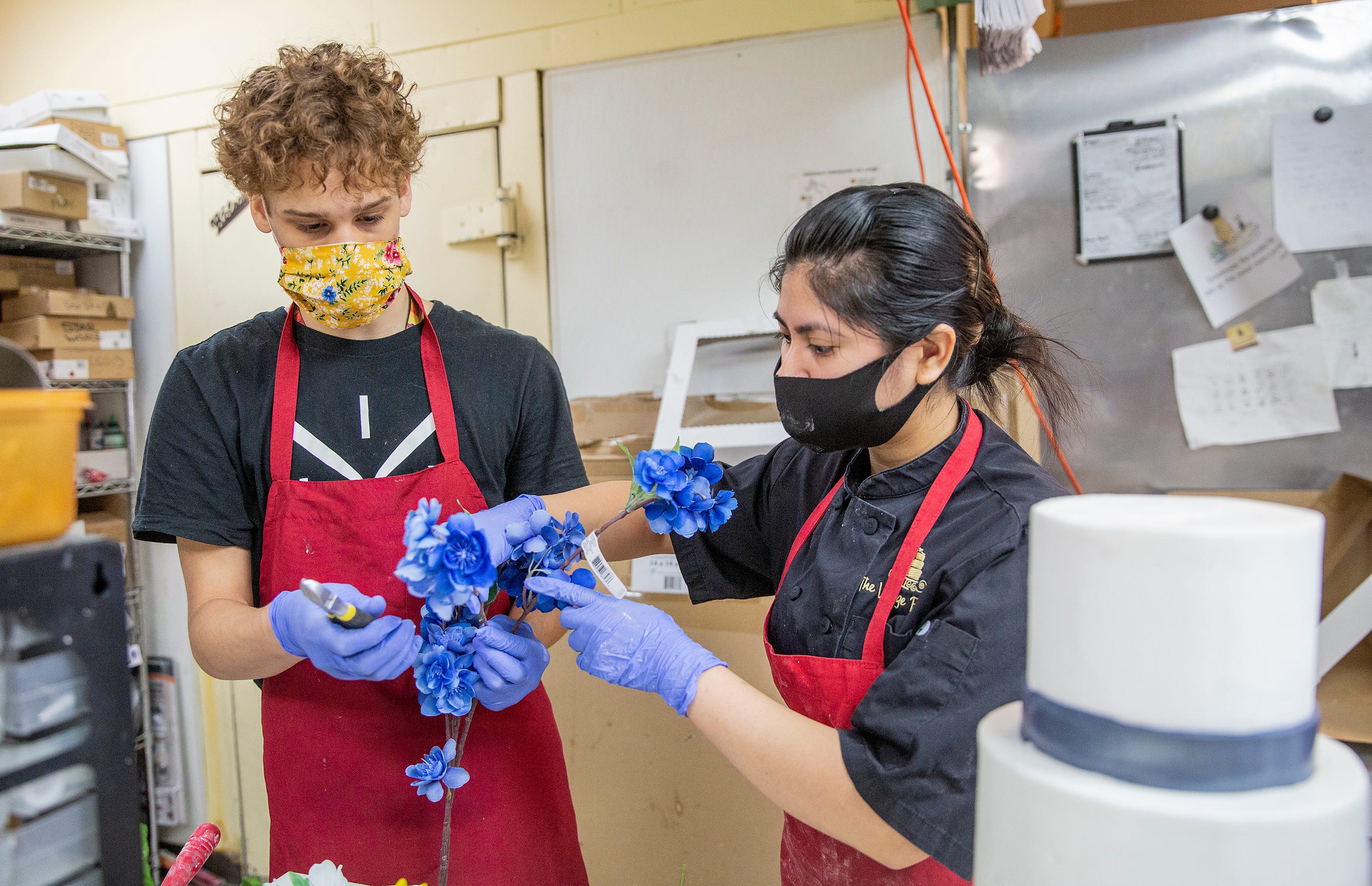 Krishna Potaraju, left, who recently got a summer job working at The Village Bakery, cuts flowers for cake director Nikki Ortega in Houston, Texas, on June 5.