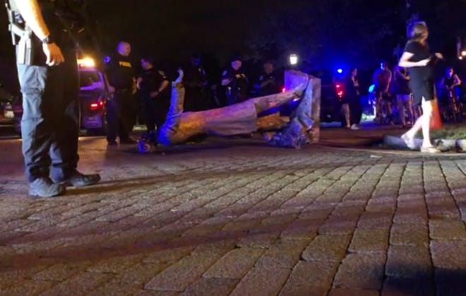 In this image from video, police stand near a toppled statue of Jefferson Davis on Wednesday night, June 10, 2020, in Richmond, Va. Protesters tore down the statue of Confederate President Davis along Monument Avenue. The statue in the former capital of the Confederacy was toppled shortly before 11 p.m., news outlets reported. (WWBT-TV via AP) ORG XMIT: NYDB711