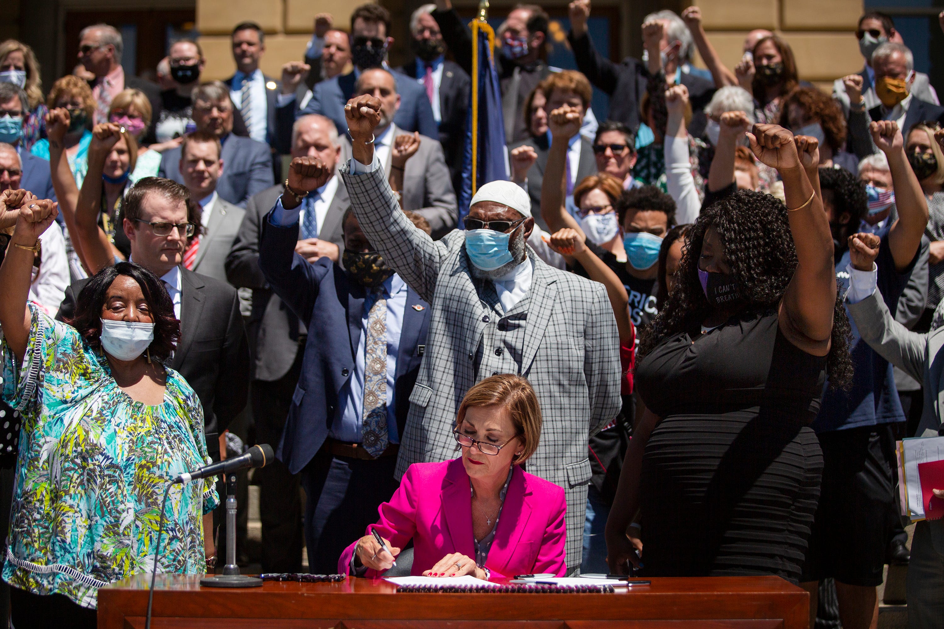 On June 12 at the Iowa Capitol, Gov. Kim Reynolds signs bipartisan legislation banning most police chokeholds and addressing officer misconduct. Protesters and other civil rights advocates had demanded legislation to address police violence. The Legislature introduced and approved the bill and the governor signed it in the span of 24 hours.