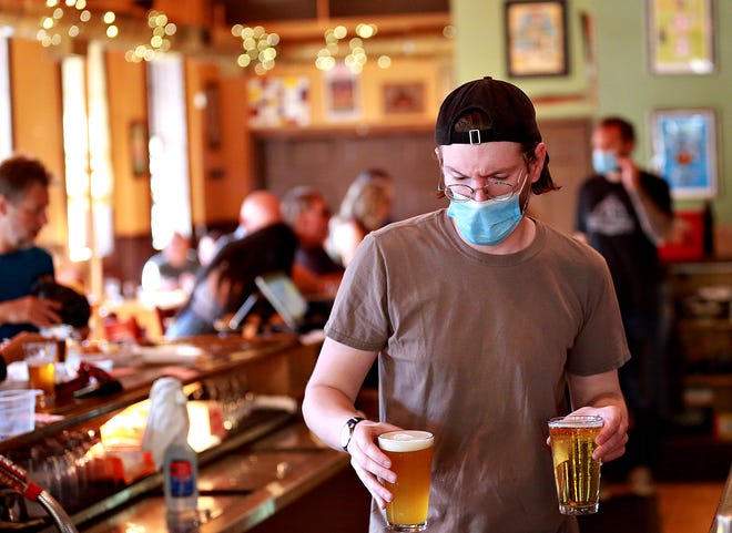 Bartender Ray Epley, of Holy Hound Taproom, serves customers at the restaurant/bar in York City, Friday, June 12, 2020. Friday would be day one for York County entering into the green phase of Gov. Wolf's plan to reopen Pennsylvania following nearly three months of restrictions placed to mitigate the spread of the coronavirus. Dawn J. Sagert photo