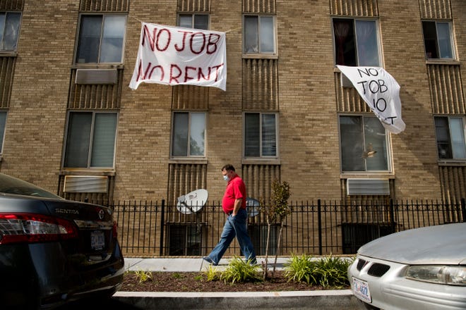FILE - In this May 20, 2020, file photo, signs that read "No Job No Rent" hang from the windows of an apartment building during the coronavirus pandemic in Northwest Washington. The pandemic has shut housing courts and prompted authorities around the U.S. to initiate policies protecting renters from eviction. But not everyone is covered, and some landlords are turning to threats and harassment to force tenants out. (AP Photo/Andrew Harnik, File)