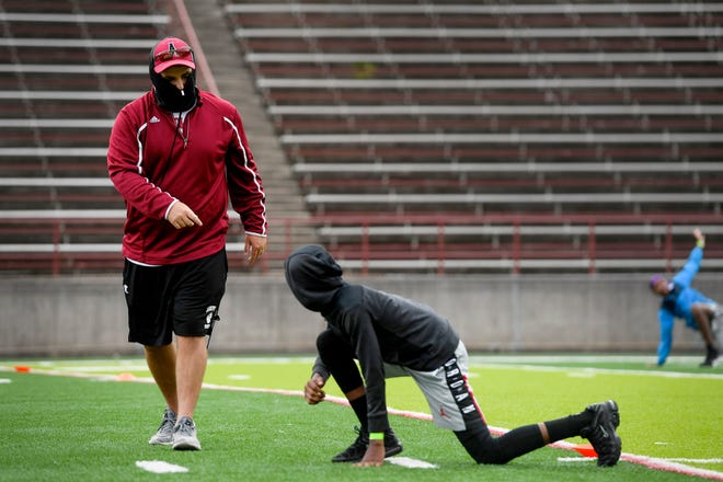 Asheville High football coach Cort Radford talks to freshman Nicolas Williams during warmups at practice June 16, 2020. Williams said he was "very excited" for the sport to return and that he was still getting used to the high school level.