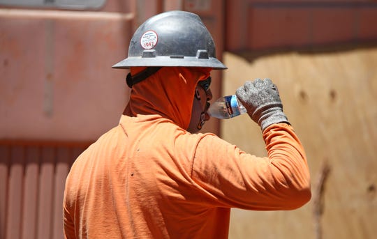 A construction worker drinks water to stay hydrated in Phoenix on June 16, 2020.