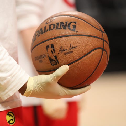 An Atlanta Hawks ball boy wears rubber gloves duri