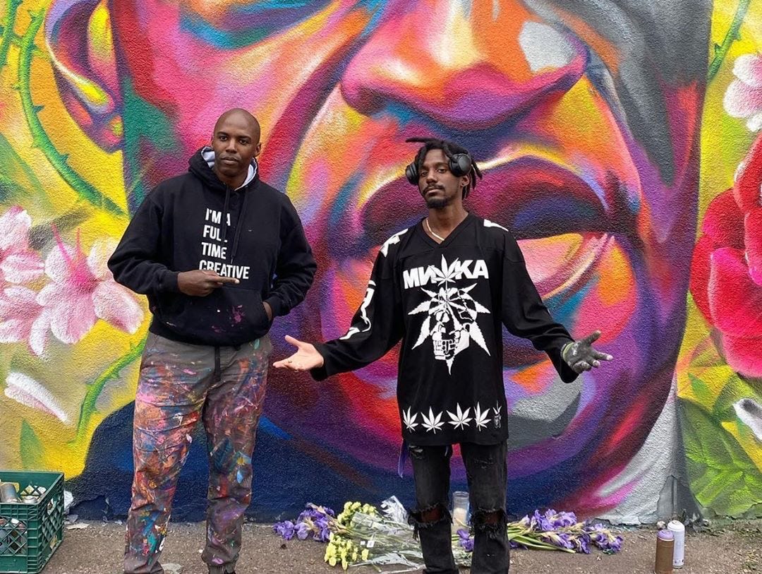 Thomas "Detour" Evans and Hiero Veiga pose in front of their artwork.