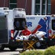 A person is brought to a medical transport vehicle from Banner Desert Medical Center as several transports and ambulances are shown parked outside the emergency room entrance, Tuesday, June 16, 2020, in Mesa.