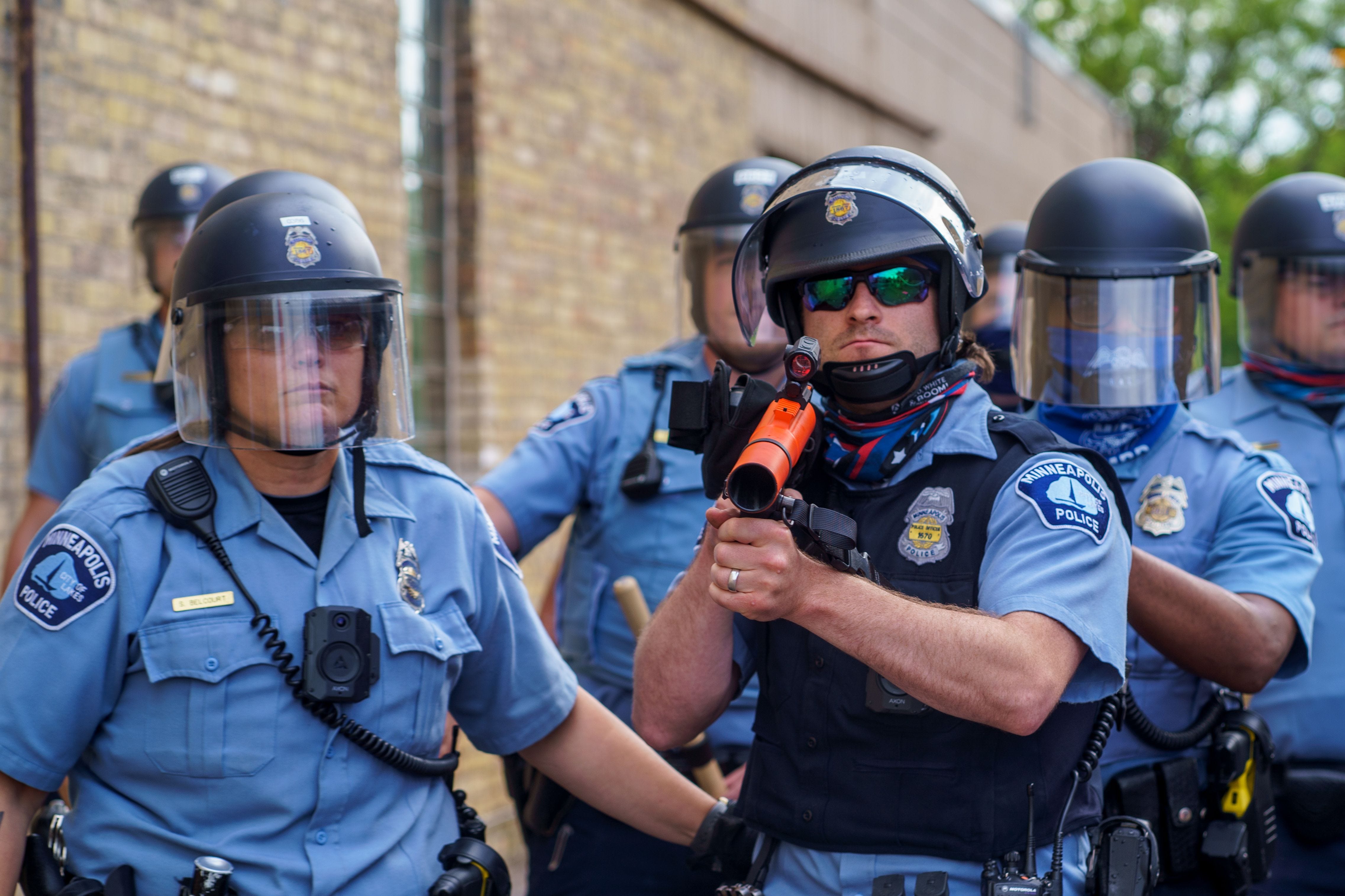 A police officer aims a projectile weapon at protesters calling for justice after George Floyd's death outside the 3rd Police Precinct on May 27, 2020, in Minneapolis.