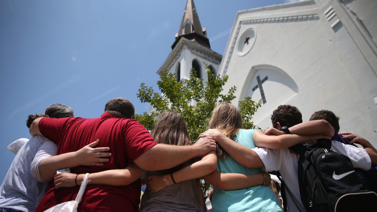 In this July 2015 photo, a church youth group from Douthan, Alabama, prays in front of the Emanuel AME Church on the one-month anniversary of the mass shooting in Charleston, South Carolina. Visitors from around the nation visited the makeshift shrine in front of the church in a show of faith and solidarity with "Mother Emanuel", as the church is known in Charleston. Nine people were killed by white supremacist Dylann Roof, who was sentenced to death for the   murders.