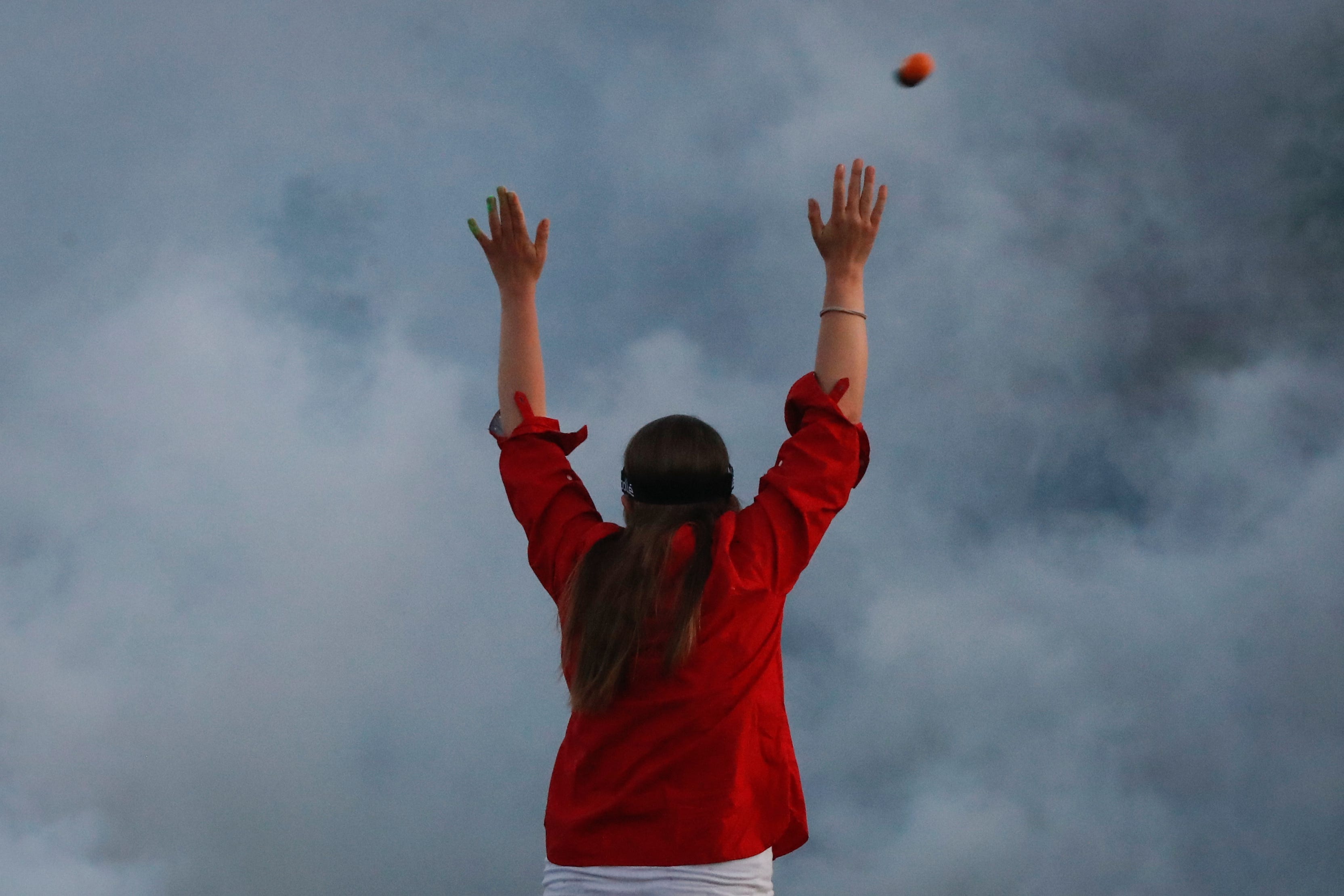 A rubber bullet is fired over a protester by police hidden by a cloud of tear gas, Saturday, May 30, 2020, in Minneapolis.