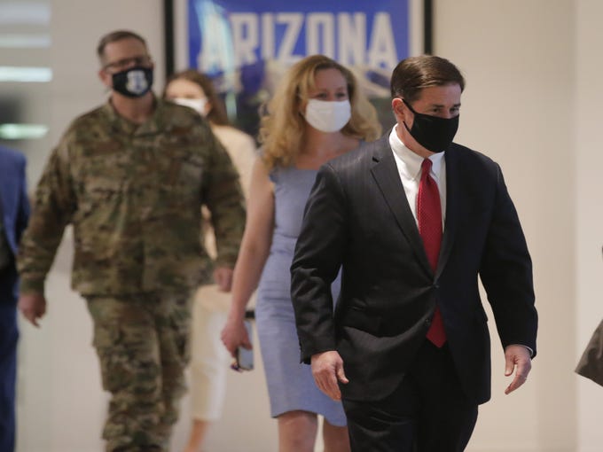 Gov. Doug Ducey along with Dr. Cara Christ, director of Arizona Department of Health Services, and Maj. Gen. Michael McGuire walk to a room to update the state on COVID-19 during a news conference in Phoenix on June 17, 2020.