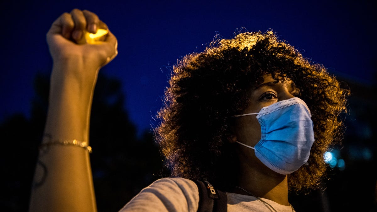 A protester raises her hand during a protest on the fifth day following Rayshard Brooks death by police in a restaurant parking lot, in Atlanta, Georgia on June 17, 2020.