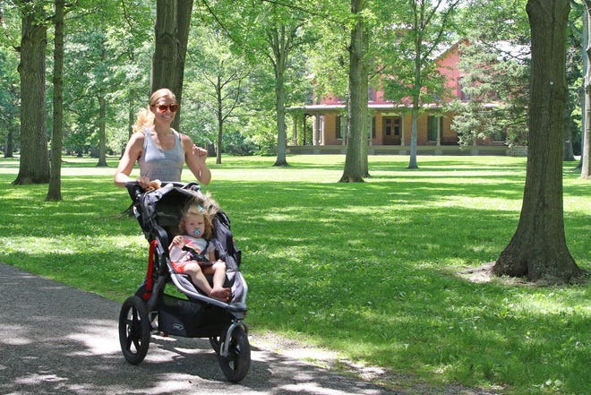 Kelly Fahle of Fremont goes on an afternoon jog at Spiegel Grove, as her daughter Anne enjoys the ride.