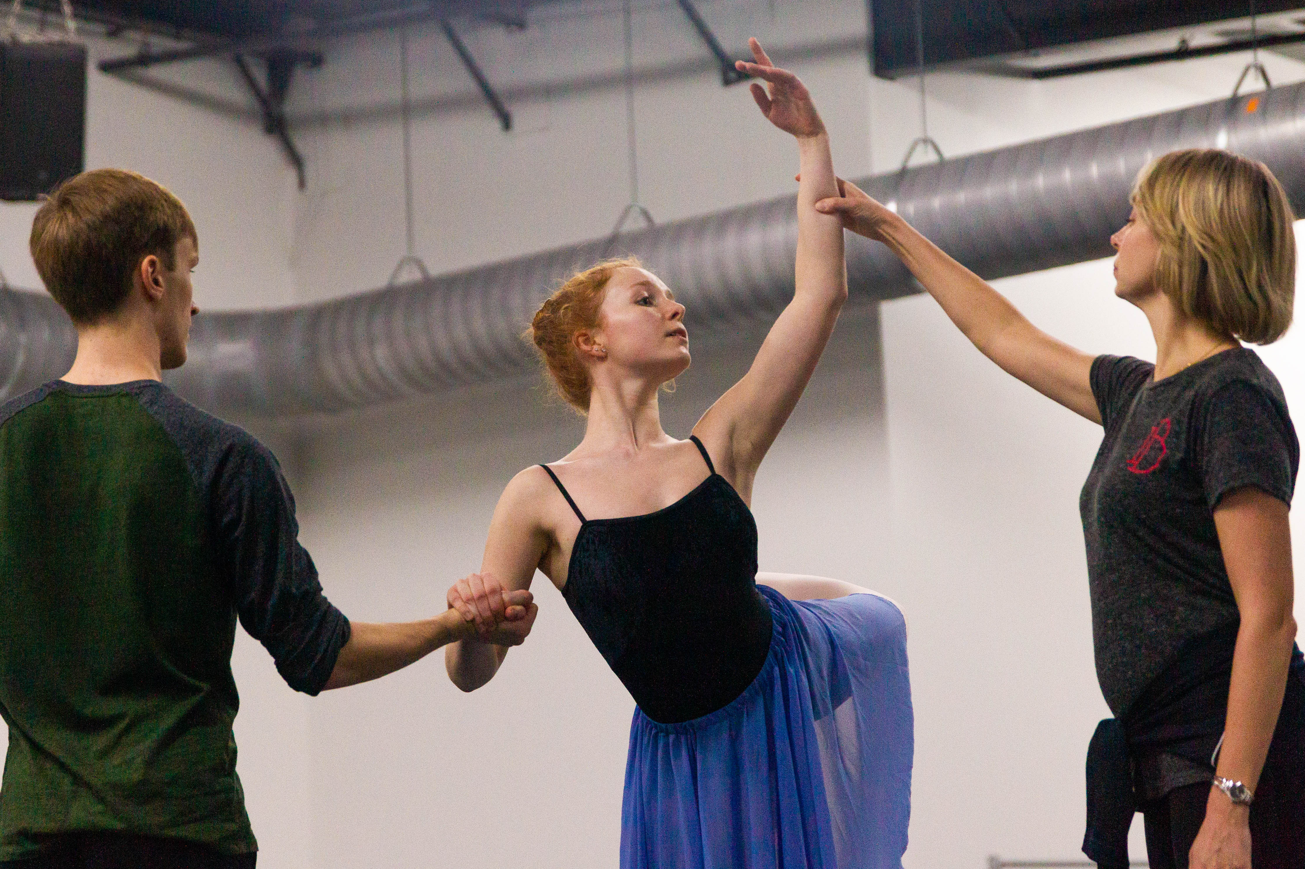 Gabrielle Brown holds on to Gabriel Paluszak's hand while ballet mistress Vlada Kysselova helps her reach a position during a rehearsal for the part of Peasant Pas, Jan. 8, 2020.